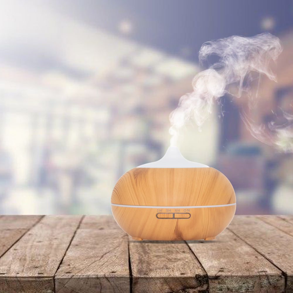 Lichte houten aroma diffuser met witte bovenkant en afstandsbediening. Voorzien van timeropties (1u, 3u, 6u, continu) en LED-verlichting.