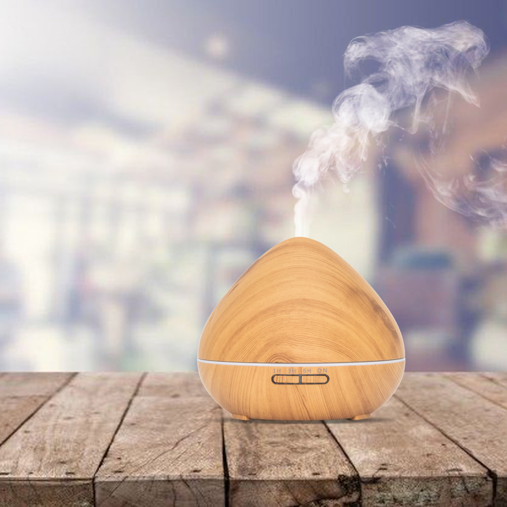 Lichte houten aroma diffuser in druppelvorm met LED-lichtstrip en afstandsbediening. Inclusief timeropties (1u, 3u, 6u, continu) en lichtinstellingen.